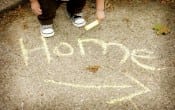 The word home written in chalk on a floor