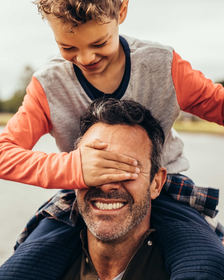 Father and son smiling and playing. Image by Maguire Family Law, leadings family law solicitors and legal firm.
