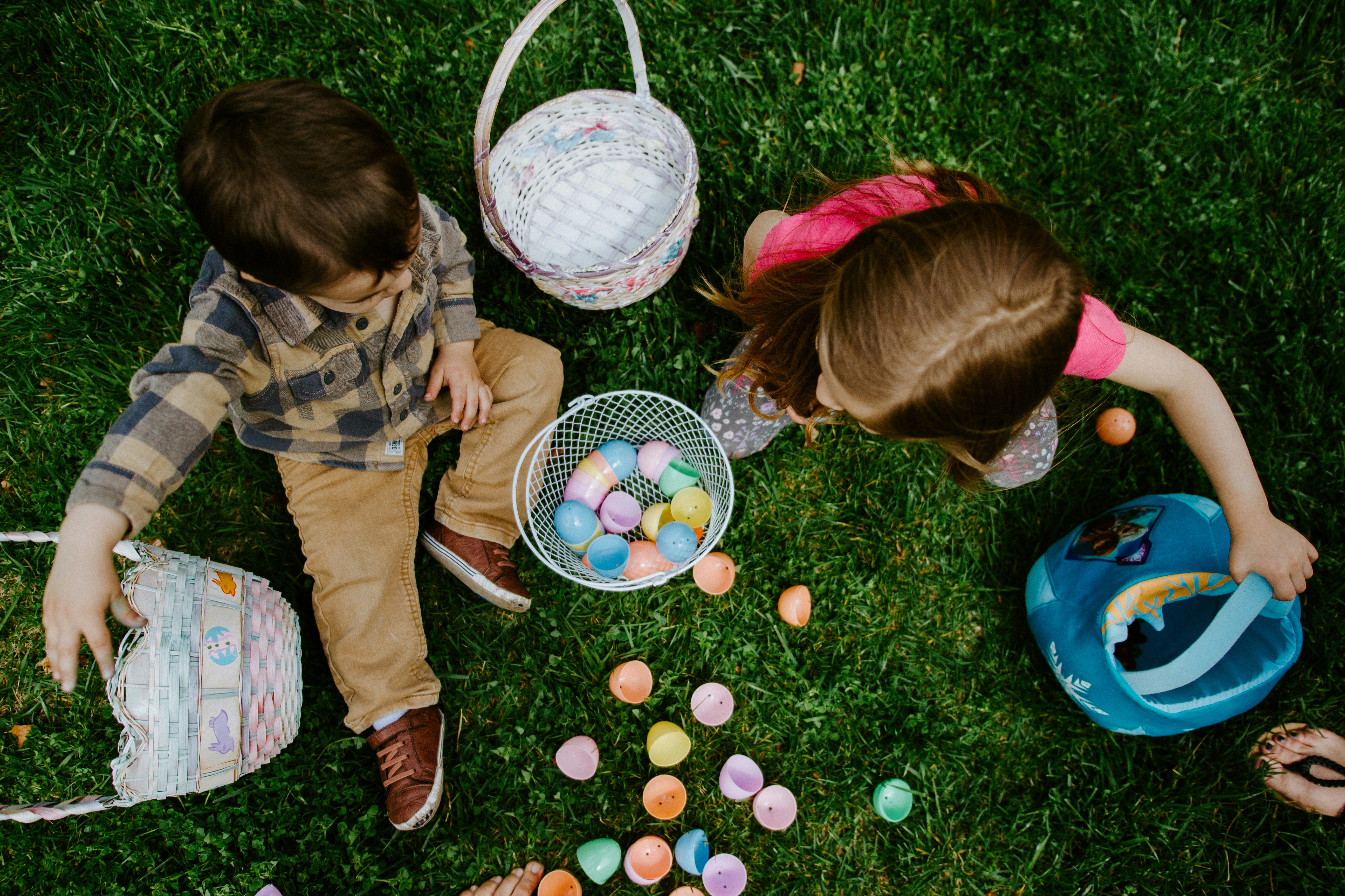 Two children playing a lawn with Easter eggs